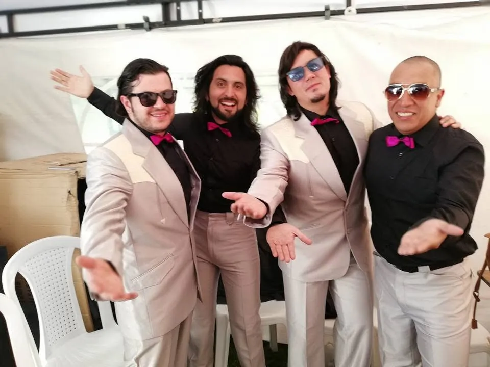 Mateo Acevedo y los integrantes de su banda posan con trajes claros y corbatines antes de un evento.