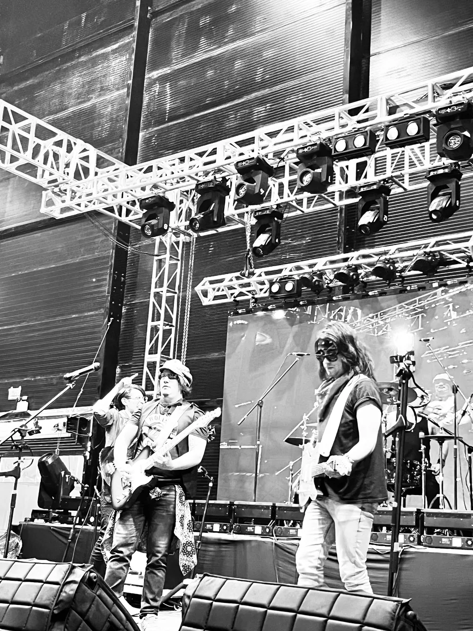 Mateo Acevedo con su banda sobre la tarima de un gran escenario durante un festival, en blanco y negro.
