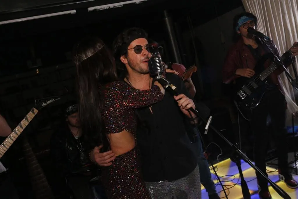 Mateo Acevedo canta al micrófono con gafas de sol durante una presentación en vivo al aire libre.