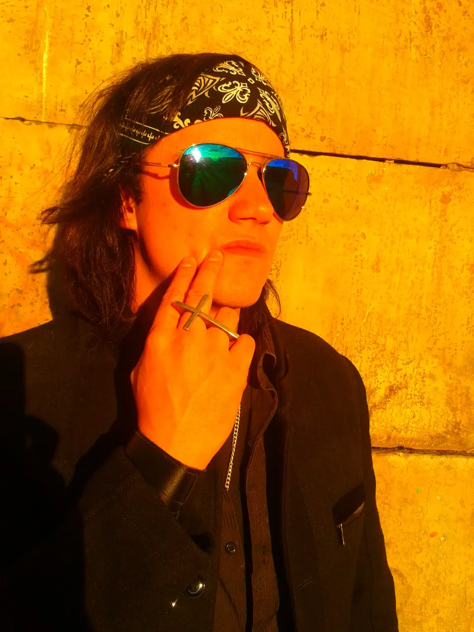 Retrato de Mateo Acevedo con pañoleta y gafas sobre fondo naranja