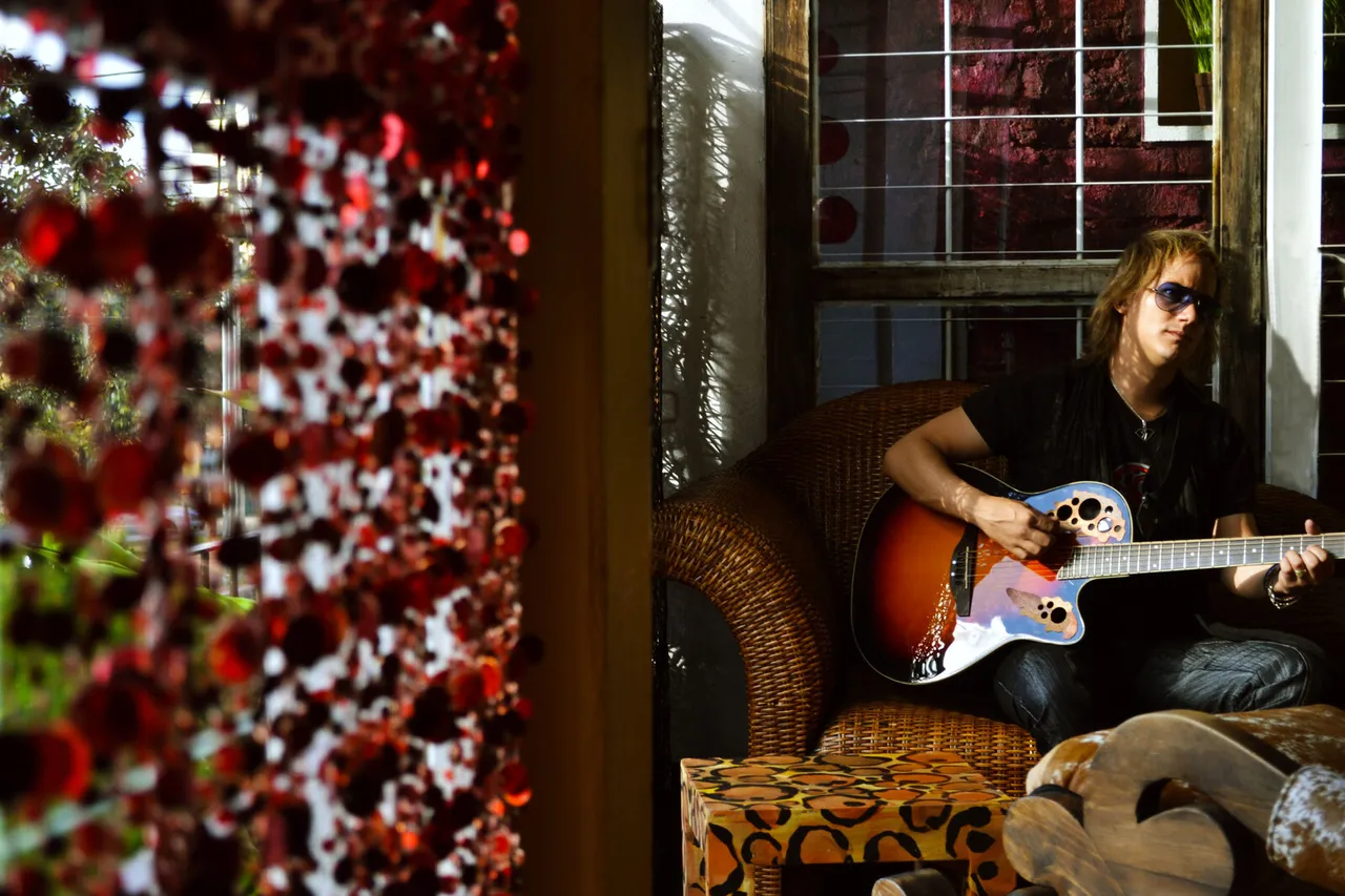 Mateo Acevedo tocando guitarra eléctrica en un ambiente lounge