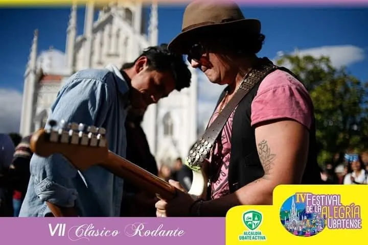 Mateo Acevedo concentrado tocando guitarra eléctrica durante un festival al aire libre frente a una catedral.