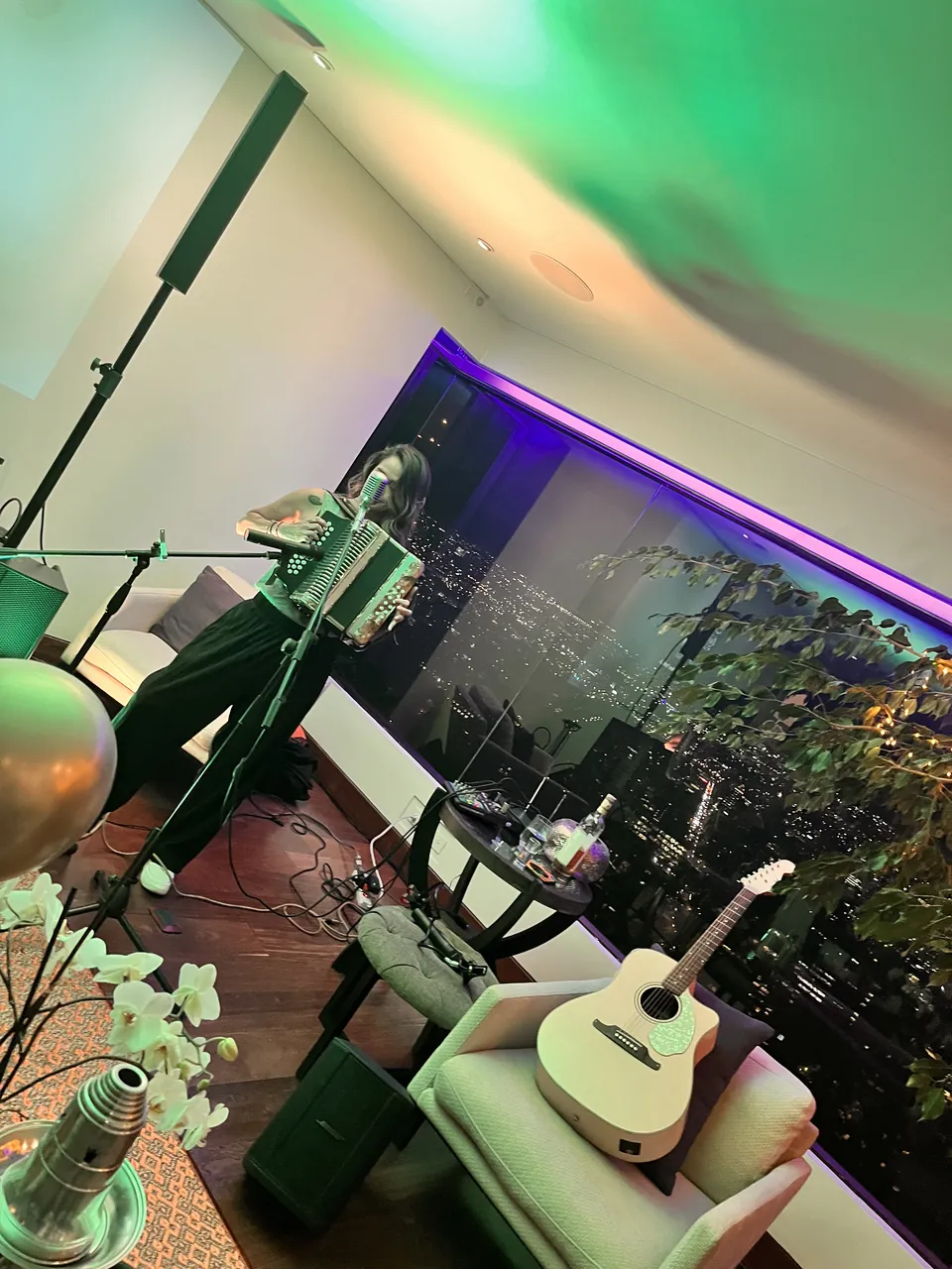 Montaje de música en vivo en un evento privado, con guitarra eléctrica, teclado, micrófonos y luces de colores.