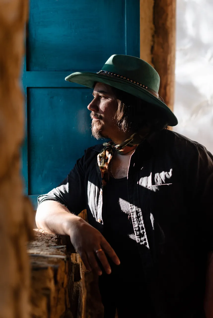 Retrato de Mateo Acevedo con sombrero en un ambiente rústico